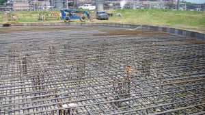 A construction site with the iron framework for the foundation in place