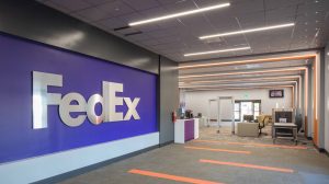 The entrance to a FedEx office space. FedEx is written on one wall, and a security entrance is seen on the right.