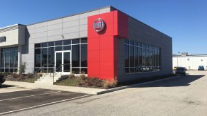 A Fiat car dealership with a red accent wall next to the main entrance.