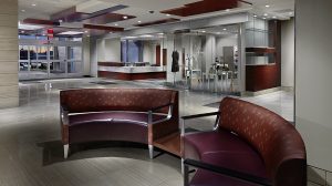 A hospital lobby with brown leather seating and a reception area in the background