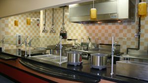 A cafeteria kitchen with yellow and white check tile on the walls