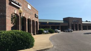 The exterior of a shopping center viewed from the side.