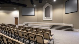 A church sanctuary with rows of chairs facing the stage.
