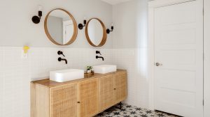 A modern bathroom with a double vanity and black and white tile