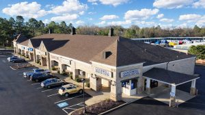Aerial view of a shopping center with a drive through and cars in the parking lot