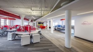An open office space with white walls and red accents