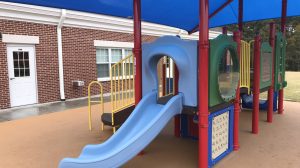 A blue slide on a school playground.