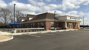 The entrance of a school with a playground to the left of it.