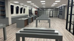 The interior of a store with tables down the middle and cabinets lining the walls.