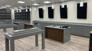 The interior of a dispensary. Cabinets and shelving line one wall with tables in the middle.