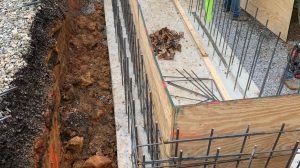 Construction worker installs plywood for a concrete foundation