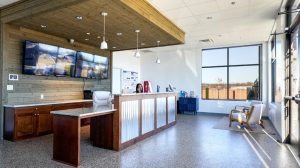 A waiting room with a kitchen island in the middle and two chairs in the waiting area.